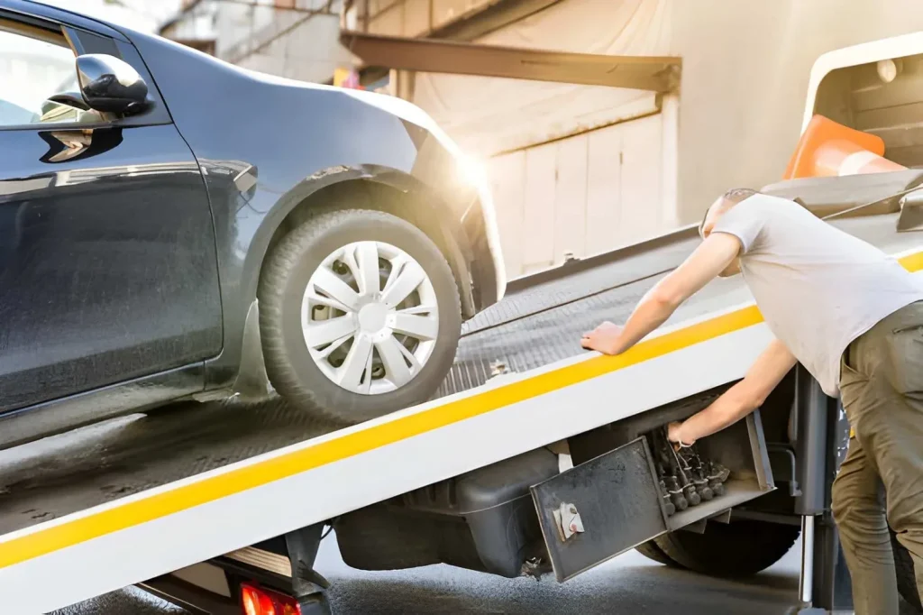 Car being loaded onto a flatbed tow truck