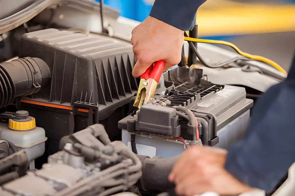Roadside assistance technician giving a car a jump start